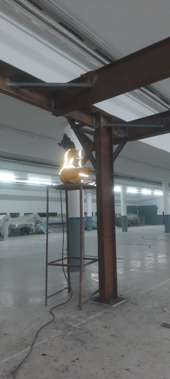 Welder working at height with full personal protective equipment