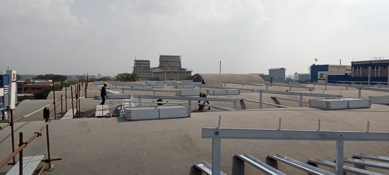 Rooftop Solar Installation — Module staging and structure alignment on a live factory roof