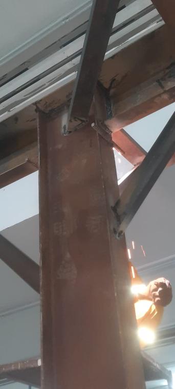 Beam Welding at Height — Certified welder completing a braced gusset connection